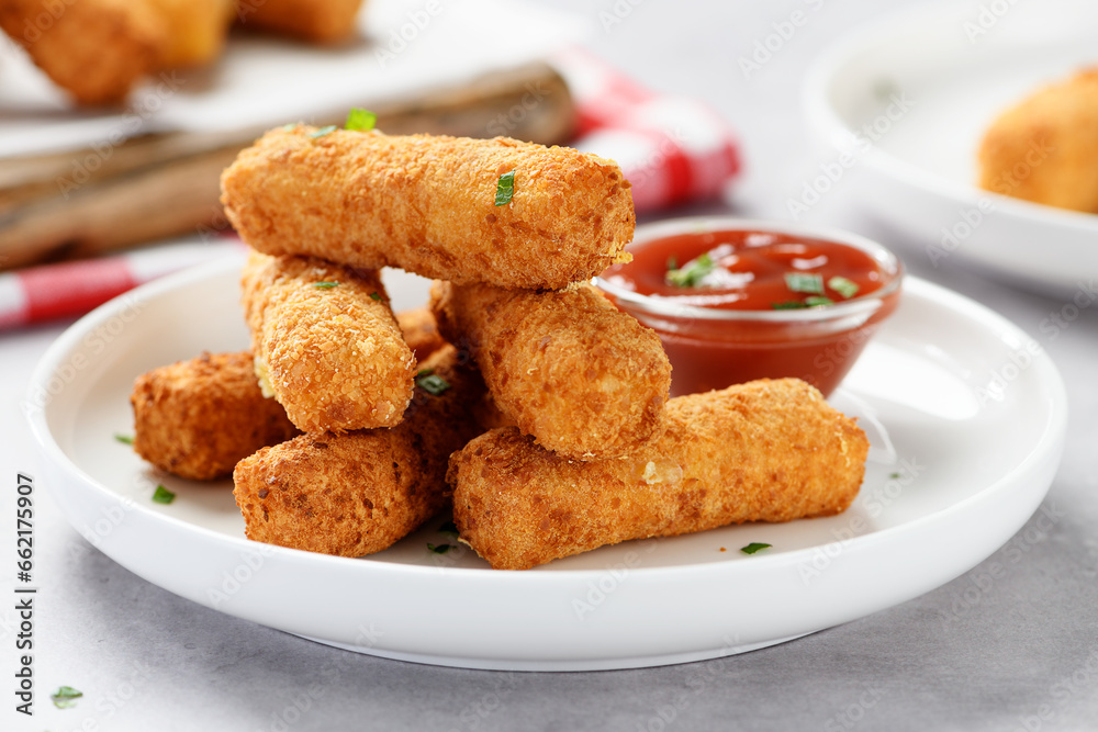 Breaded fried mozzarella cheese sticks with tomato dipping sauce. Breaded fried mozzarella cheese sticks with tomato dipping sauce.