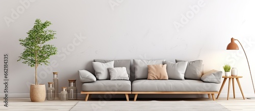 Real photo of modern living room with patterned pillows on grey couch pouf and wooden table With copyspace for text