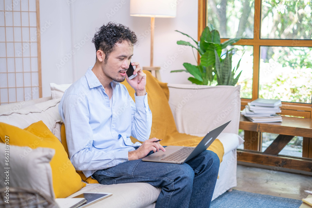 Professional entrepreneur businessman use modern mobile phone technology talking business communication laptop sitting on sofa indoor living room home, adult male man person talking smiling smartphone Professional entrepreneur businessman use modern mobile phone technology talking business communication laptop sitting on sofa indoor living room home, adult male man person talking smiling smartphone