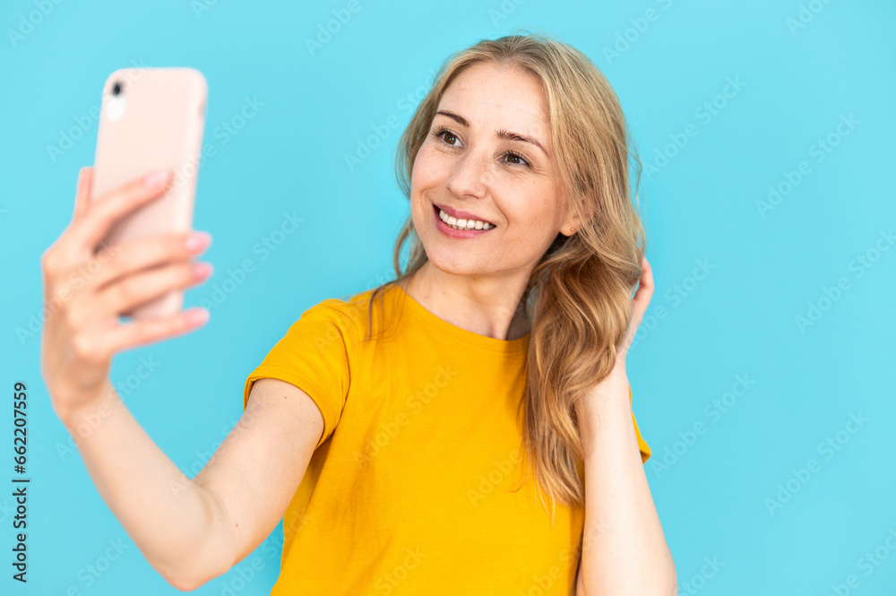Happy smiling woman holding smartphone and talking at video call