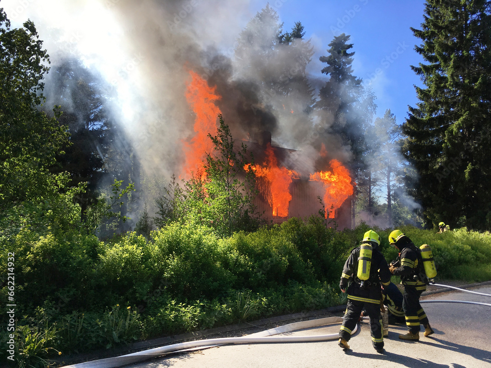 Fototapeta premium Firefighters put out burning house