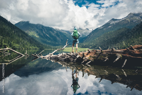 Hiking woman on a one plank bridge in high altitude mountains photo