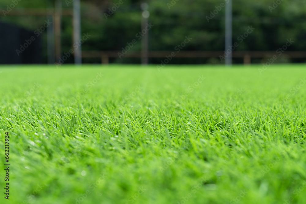 Artificial grass close-up. Artificial turf background. Artificial turf of Soccer football field. Short cut real grass on the edge of the pitch in the stadium.