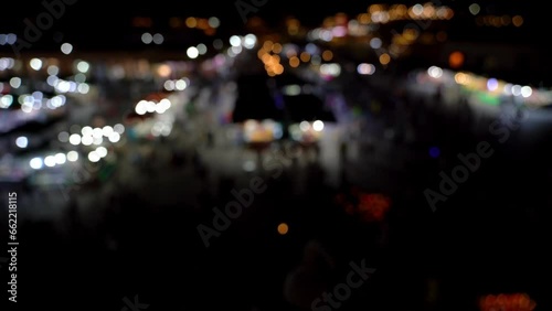 Jemma el Fnaa square in Marrakesh, Morocco at night is a vibrant market square with many people and motion. Out of focus and bokeh video done on purpose. photo