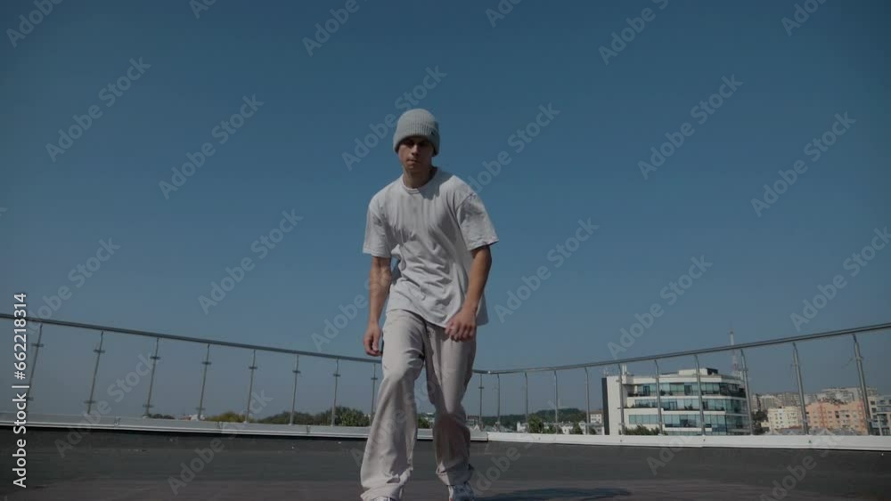 The guy coolly dances breakdance on the roof of the house. A man dances an energetic athletic dance.
The guy coolly dances breakdance on the roof of the house. A man dances an energetic athletic dance.