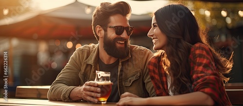 Print op canvas Joyful pair enjoying beer at outdoor pub or bar With copyspace for text