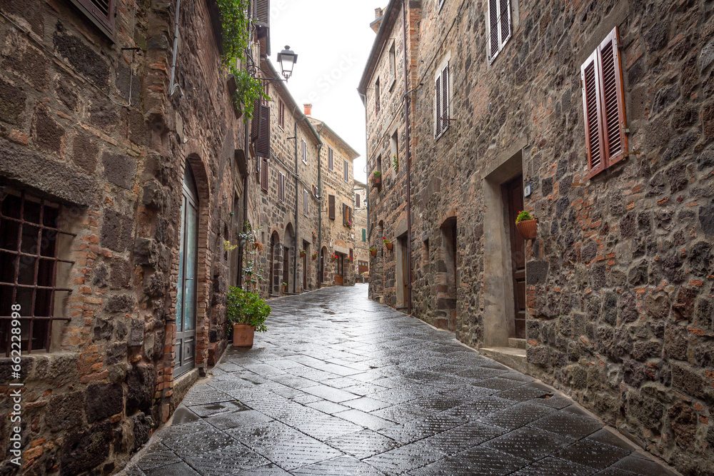 a narrow street with traditional houses in Radicofani, province of Siena, Tuscany, Italy