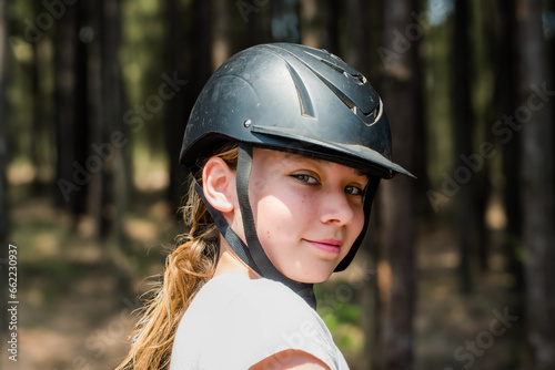 Pretty young girl taking a horseback ride in the forest © Image'in