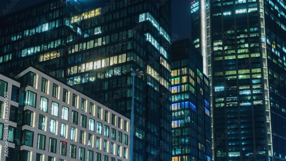 Day to night transition blinking office window lights time-lapse, windows grid, high-rise skyscraper business buildings in downtown, glass surface, turn on and off lights, people working in evening