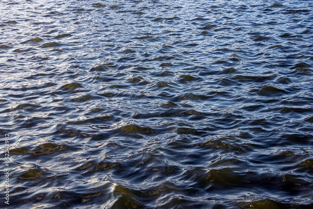 Natural small waves ripples on the surface of the water with reflection of sunlight Natural small waves ripples on the surface of the water with reflection of sunlight
