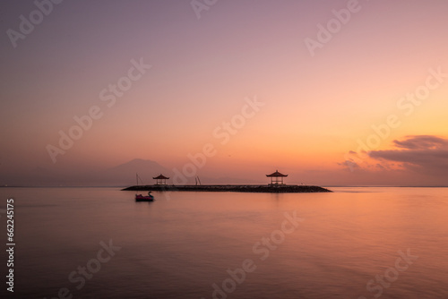 Landscape shot in Bali. Sunrise or sunset at Sanur beach. Beautiful sandy beach in the morning, with fine sand and a view of the calm sea. Temples are in the water. A dream in Indonesia