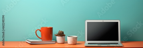 A present-day desk setup including a laptop and a coffee mug photo