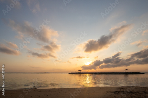 Landscape shot in Bali. Sunrise or sunset at Sanur beach. Beautiful sandy beach in the morning  with fine sand and a view of the calm sea. Temples are in the water. A dream in Indonesia