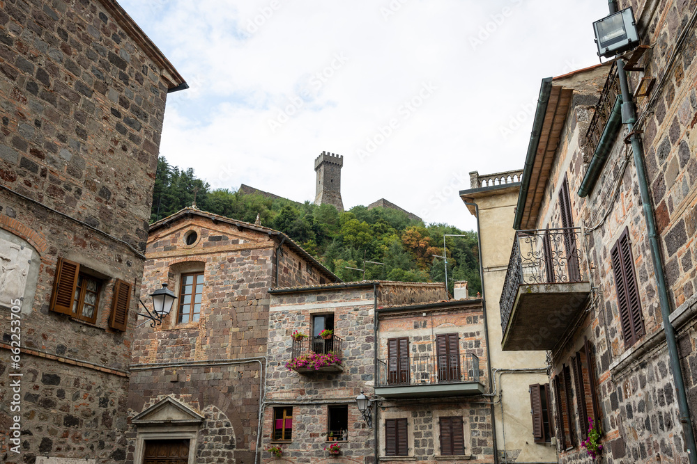 a street with traditional houses with a view to the castle in Radicofani, province of Siena, Tuscany, Italy