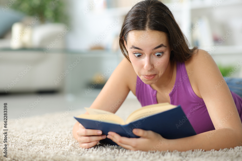 Surprised female reading a paper book at home Surprised female reading a paper book at home