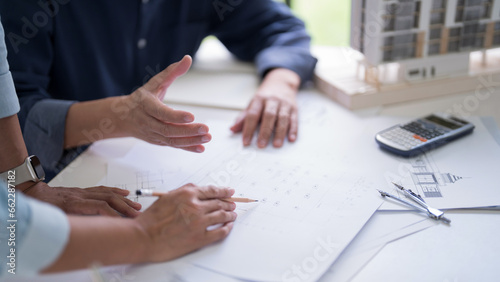 Fototapeta Naklejka Na Ścianę i Meble -  Two engineer architect discussion and inspecting sketching about interior architectural building on blueprint to analysis technical for construction plan while working together in workplace site