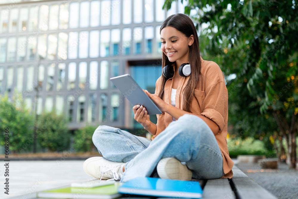 Fototapeta premium Engaged young woman student shopping online, using digital tablet