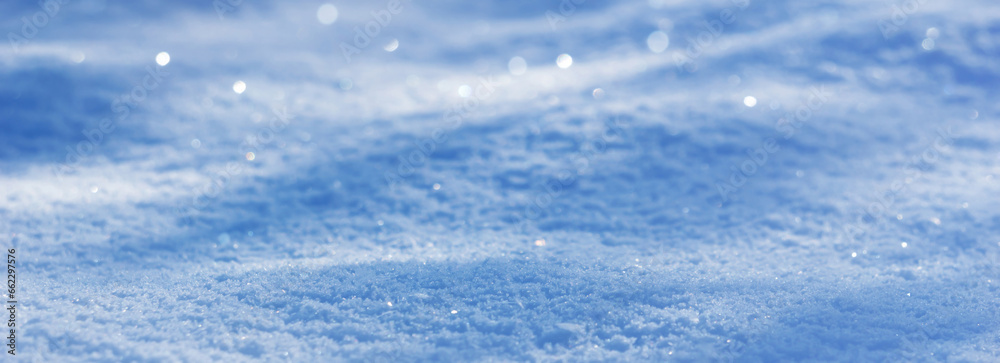 closeup of a bright white-blue snow texture with light and shadow,  glittering nature background with blur for winter vacation, travel or holidays with copy space