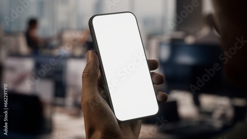 CU Black African-American male using a phone in a busy office photo