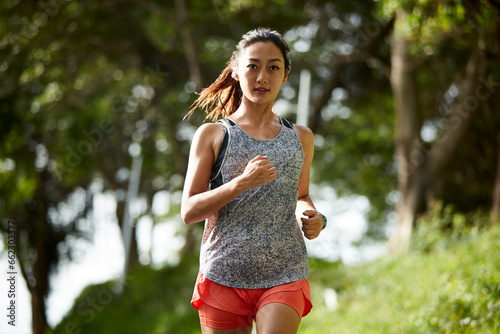 young asian woman jogging running outdoors in park photo