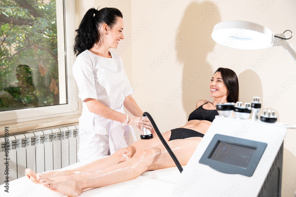 Obraz premium Vacuum massage for legs of beautiful woman in beauty clinic