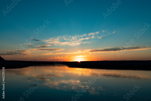 Sunset sea landscape. Colorful ocean beach sunrise. Beautiful beach scenery with calm waves and soft sandy beach.