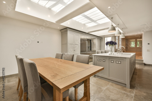 Tableau sur toile a kitchen and dining area with skylights on the ceiling over the island, which h