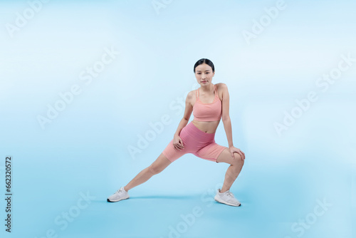 Young attractive asian woman in sportswear stretching before fitness exercise routine. Healthy body care workout with athletic woman warming up on studio shot isolated background. Vigorous