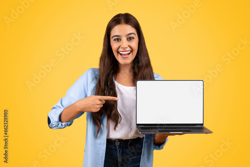 Shocked glad european teen student lady point finger on laptop