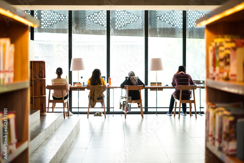 Fototapeta Naklejka Na Ścianę i Meble -  People working their own tasks on the multimedia service table at the library. working space concept. library concept