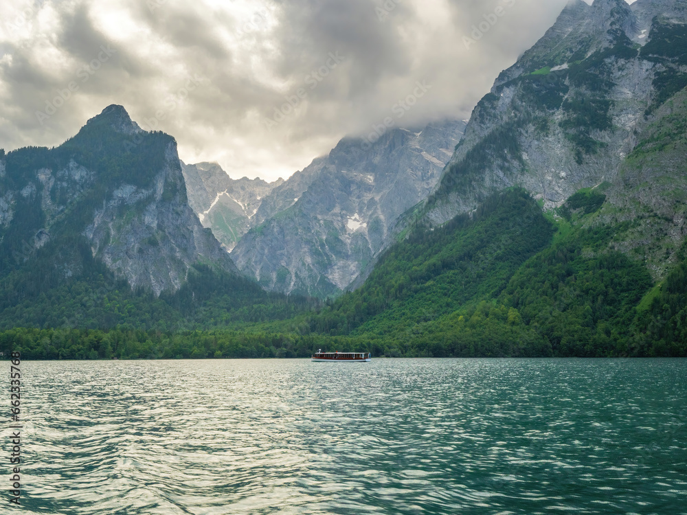 Boat ride along the crystal clear Kings lake at Berchtesgaden and the dramatic clouds at the background Boat ride along the crystal clear Kings lake at Berchtesgaden and the dramatic clouds at the background