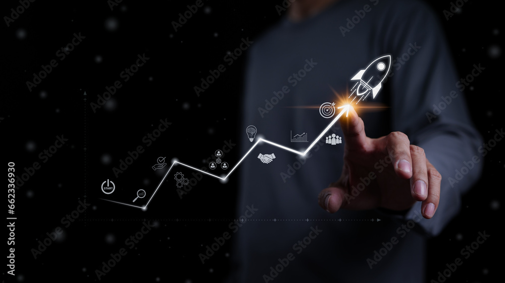 Startup business and investment concept. Businessman is touching the growing business graph. Planning and starting corporate business start up, Rocket icon soars with speed to hit the growth target. - obrazy, fototapety, plakaty 