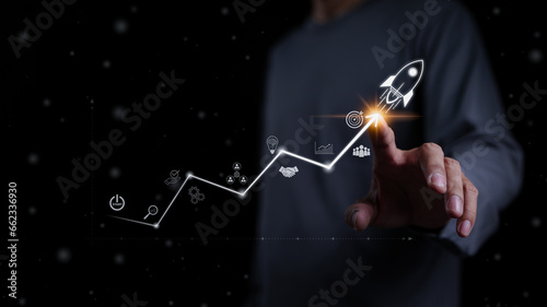 Startup business and investment concept. Businessman is touching the growing business graph. Planning and starting corporate business start up, Rocket icon soars with speed to hit the growth target.