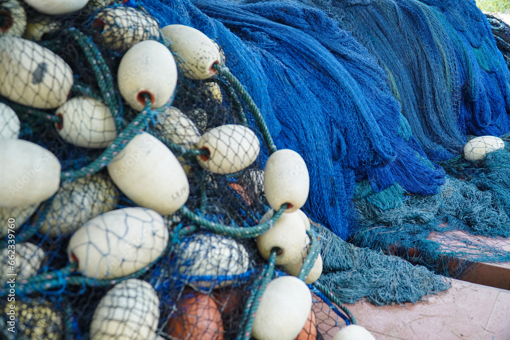 Obraz premium pile of blue fishing net with white floats. Trawler fishing net and floats. Fishing nets and ropes. tool for catching fish