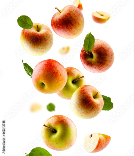 Excellently retouched multi colored apples with leaves whole halves and slices fall in space.  Surround light from behind. Isolated on white