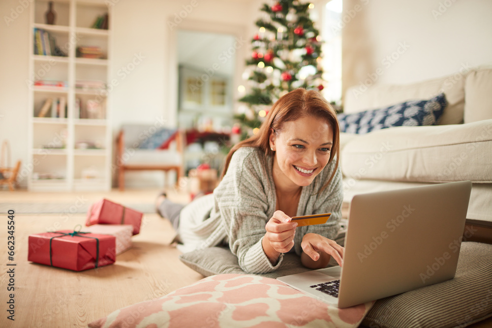 Young woman online shopping on a laptop for presents during the Christmas holidays at home Young woman online shopping on a laptop for presents during the Christmas holidays at home