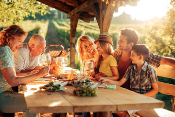 Multigenerational family having lunch in a gazebo on the vineyard