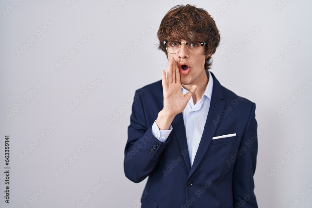 Hispanic business young man wearing glasses hand on mouth telling secret rumor, whispering malicious talk conversation Hispanic business young man wearing glasses hand on mouth telling secret rumor, whispering malicious talk conversation