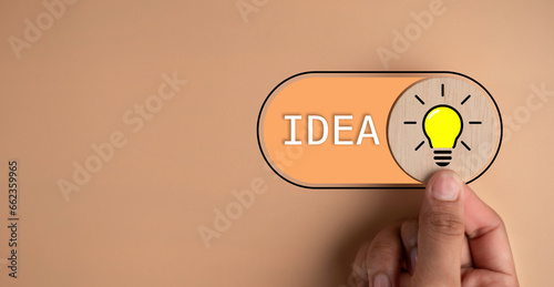 Problem solving solution and creative thinking idea innovation concept. Hand switch light bulb lamp icon to open intellect idea on orange background. Motivation for success.