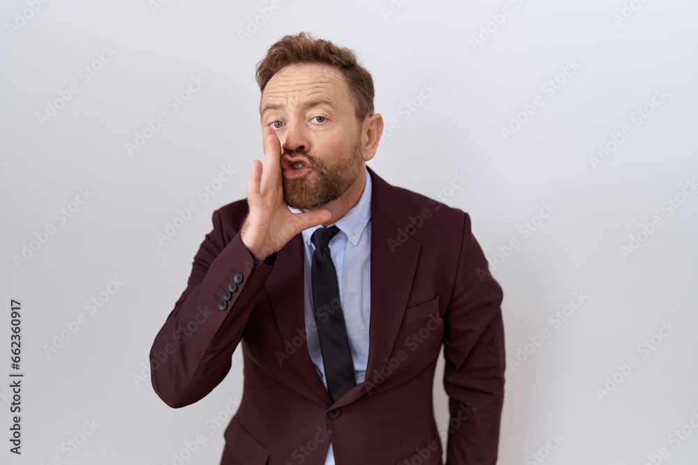 Middle age business man with beard wearing suit and tie hand on mouth telling secret rumor, whispering malicious talk conversation Middle age business man with beard wearing suit and tie hand on mouth telling secret rumor, whispering malicious talk conversation