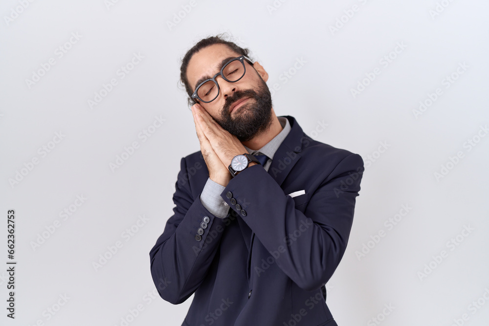 Hispanic man with beard wearing suit and tie sleeping tired dreaming and posing with hands together while smiling with closed eyes. Hispanic man with beard wearing suit and tie sleeping tired dreaming and posing with hands together while smiling with closed eyes.