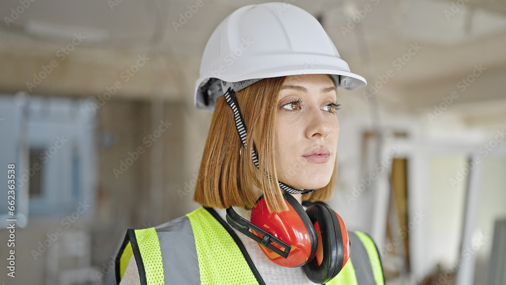 Obraz premium Young blonde woman architect standing with relaxed expression at construction site