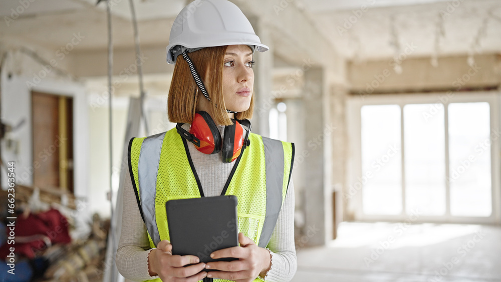 Young blonde woman architect using touchpad with serious expression at construction site Young blonde woman architect using touchpad with serious expression at construction site