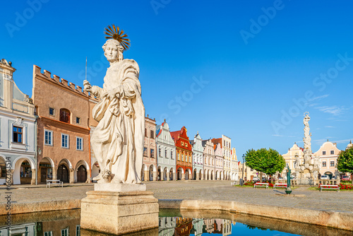 Telč, Czech Republic - 8 July 2023: Saint Margaret fountain and colorful houses on the main square in the of town of Telč photo