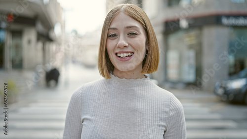 Young blonde woman smiling confident standing at street