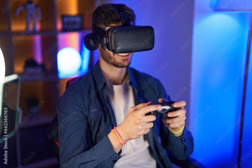 Young caucasian man streamer playing video game using virtual reality glasses and joystick at gaming room Young caucasian man streamer playing video game using virtual reality glasses and joystick at gaming room