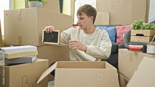 Young caucasian man packing cardboard box at new home © Krakenimages.com