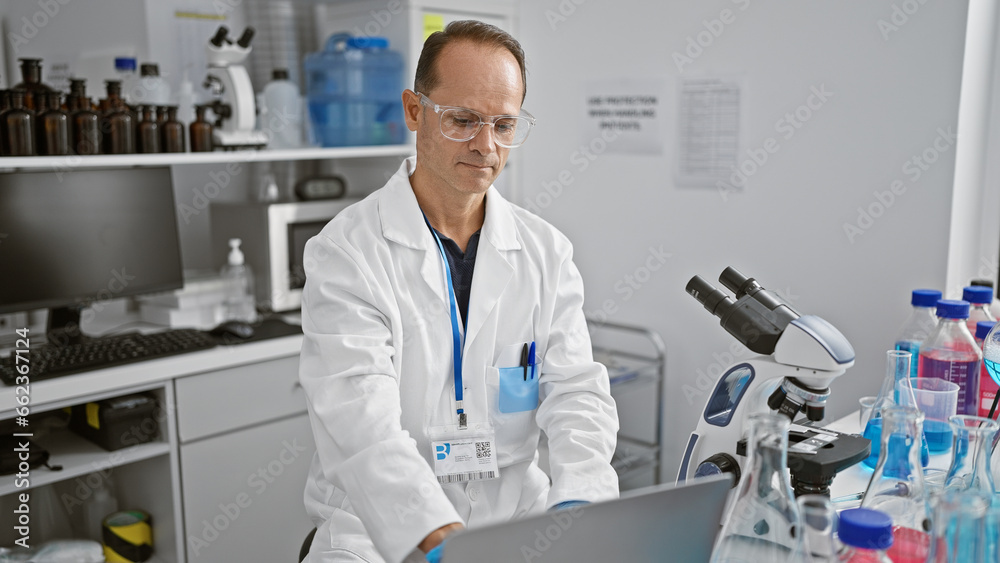 Middle age man scientist using laptop at laboratory Middle age man scientist using laptop at laboratory