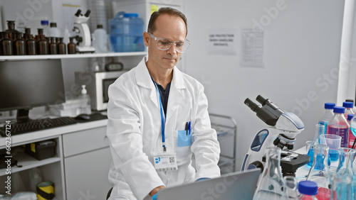 Middle age man scientist using laptop at laboratory