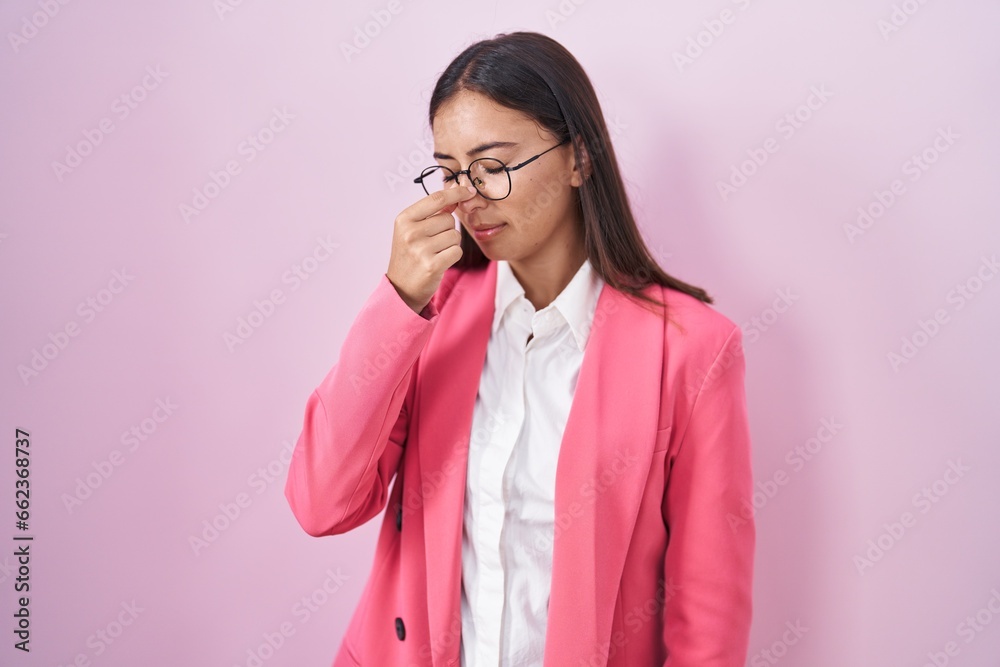 Young hispanic woman wearing business clothes and glasses tired rubbing nose and eyes feeling fatigue and headache. stress and frustration concept. Young hispanic woman wearing business clothes and glasses tired rubbing nose and eyes feeling fatigue and headache. stress and frustration concept.